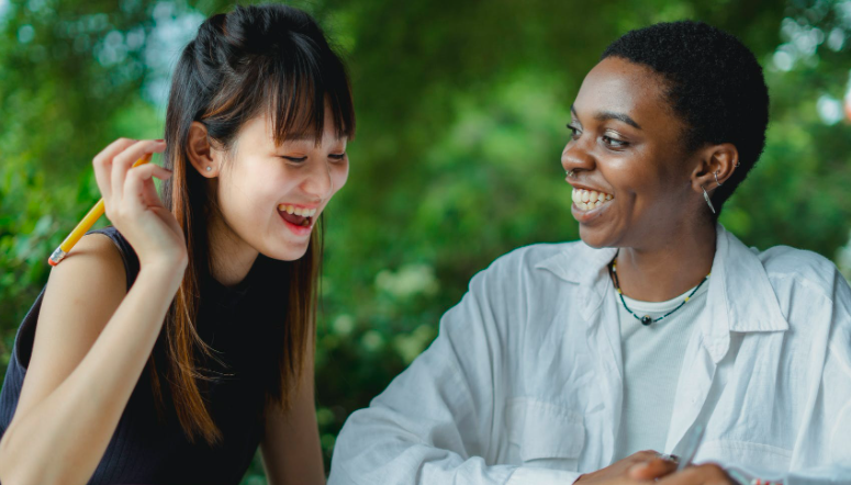 Two young women working together and smiling